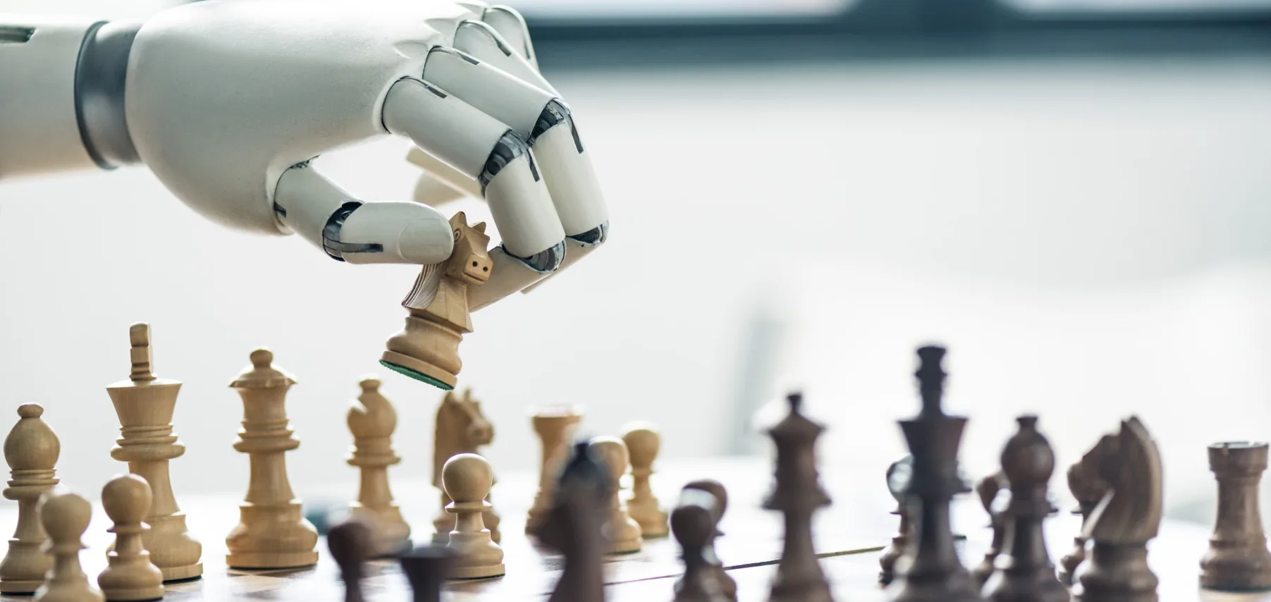 Mano robotica che sposta un cavallo su una scacchiera: le scelte strategiche sull’intelligenza artificiale in azienda